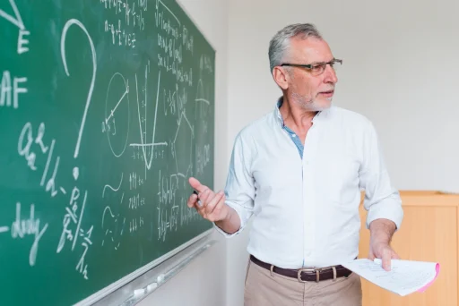 aged-math-teacher-explaining-formula-classroom
