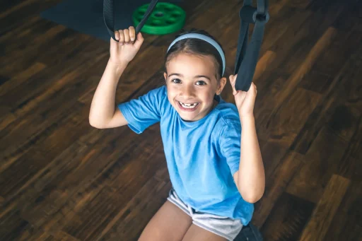 little-girl-using-trx-fitness-straps-working-with-his-own-weight
